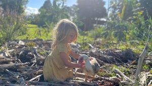 Our daughter Juneberry and one of our muscovy ducks (in Hawaii)