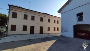 la casa a due piani e il garage sulla destra