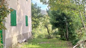 Una parte del giardino con la facciata del casale 