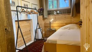 Tiny house bedroom has 2 single beds (can be made into a double) & bed/sofa in separate living area.